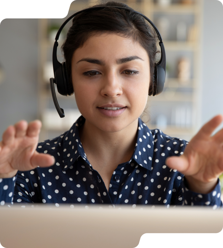 Woman on headset in front of computer.