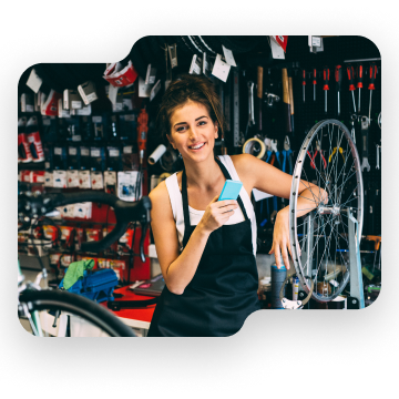 Woman holding phone at a bike shop.