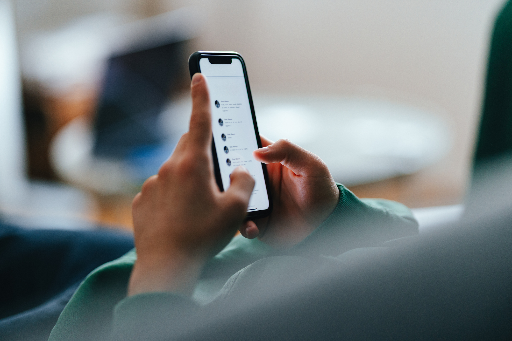 Close-up of a person using a smartphone to send and receive text messages, highlighting the speed and engagement of SMS communication in business.